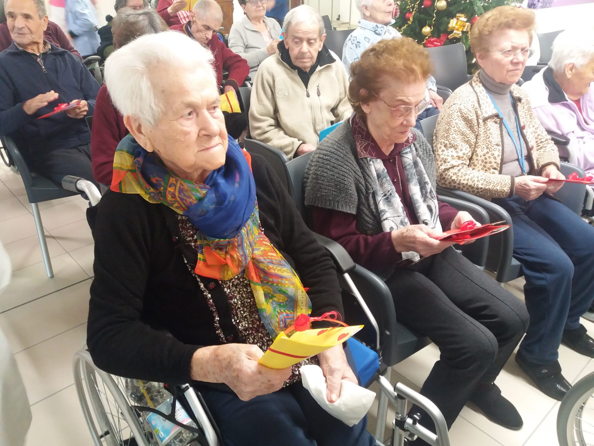Un'immagine che ritrae capispalla, sedia a rotelle, gruppo sociale, comunità e sedia.