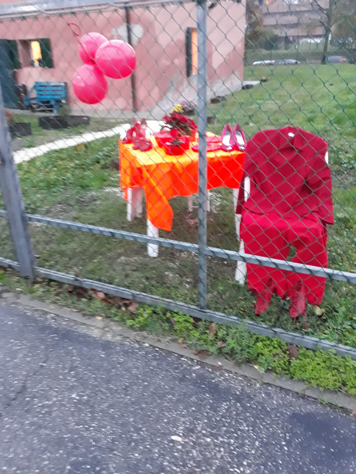 Un'immagine che ritrae rosso, forniture per feste, prato, recinzione e cortile.
