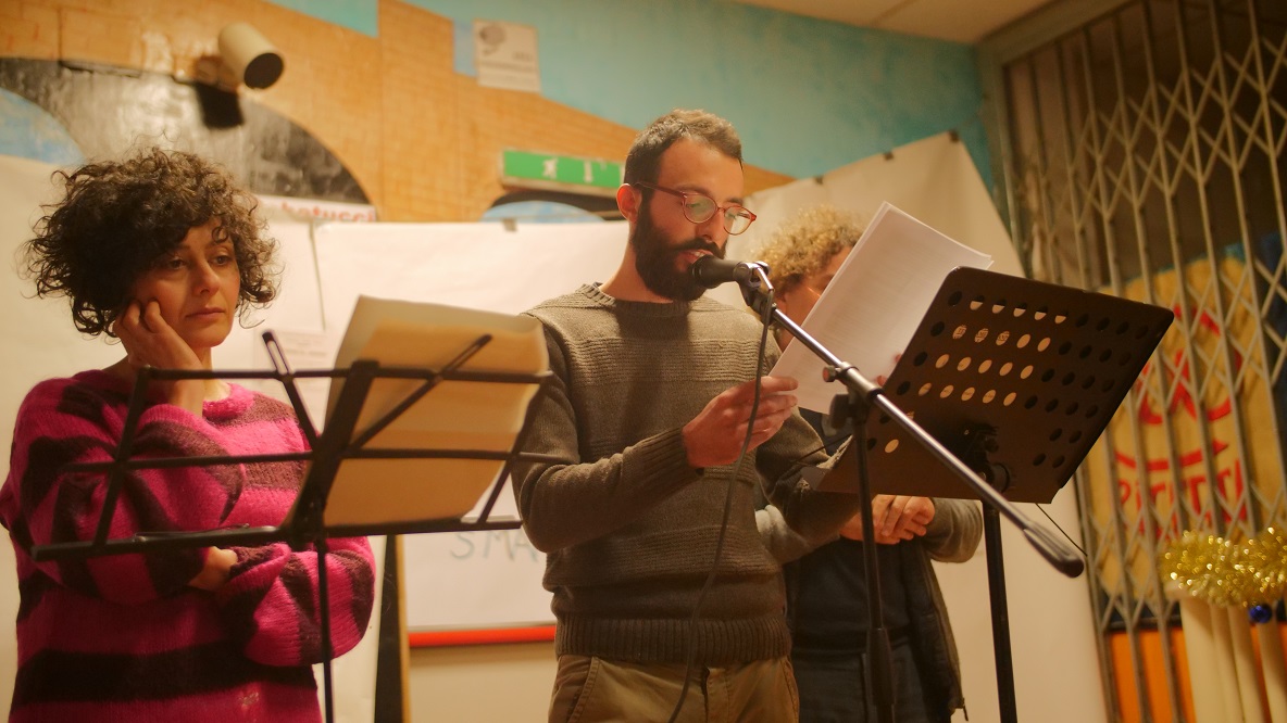 Un'immagine che ritrae vestiario, apparecchiature audio, occhiali, dispositivo elettronico e supporto per microfono.
