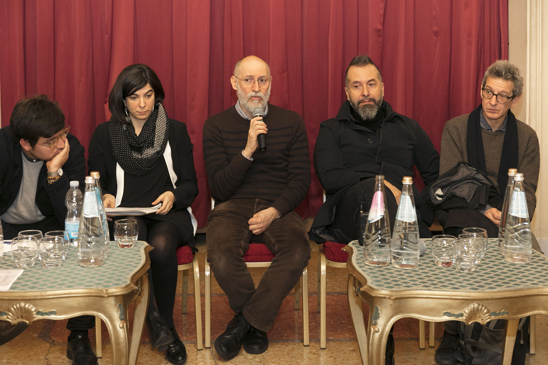 Un'immagine che ritrae viso, mobilia, capispalla, barba e seduta.