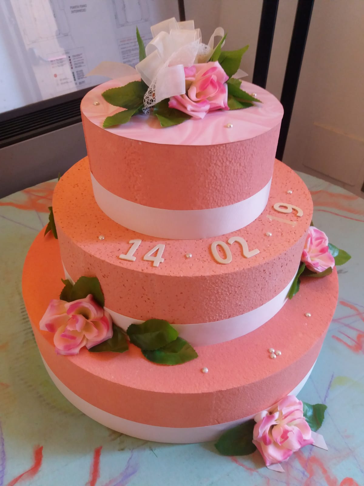 Un'immagine che ritrae torta, rosa, pasta di zucchero, decorazione di torte e glassa fondente.
