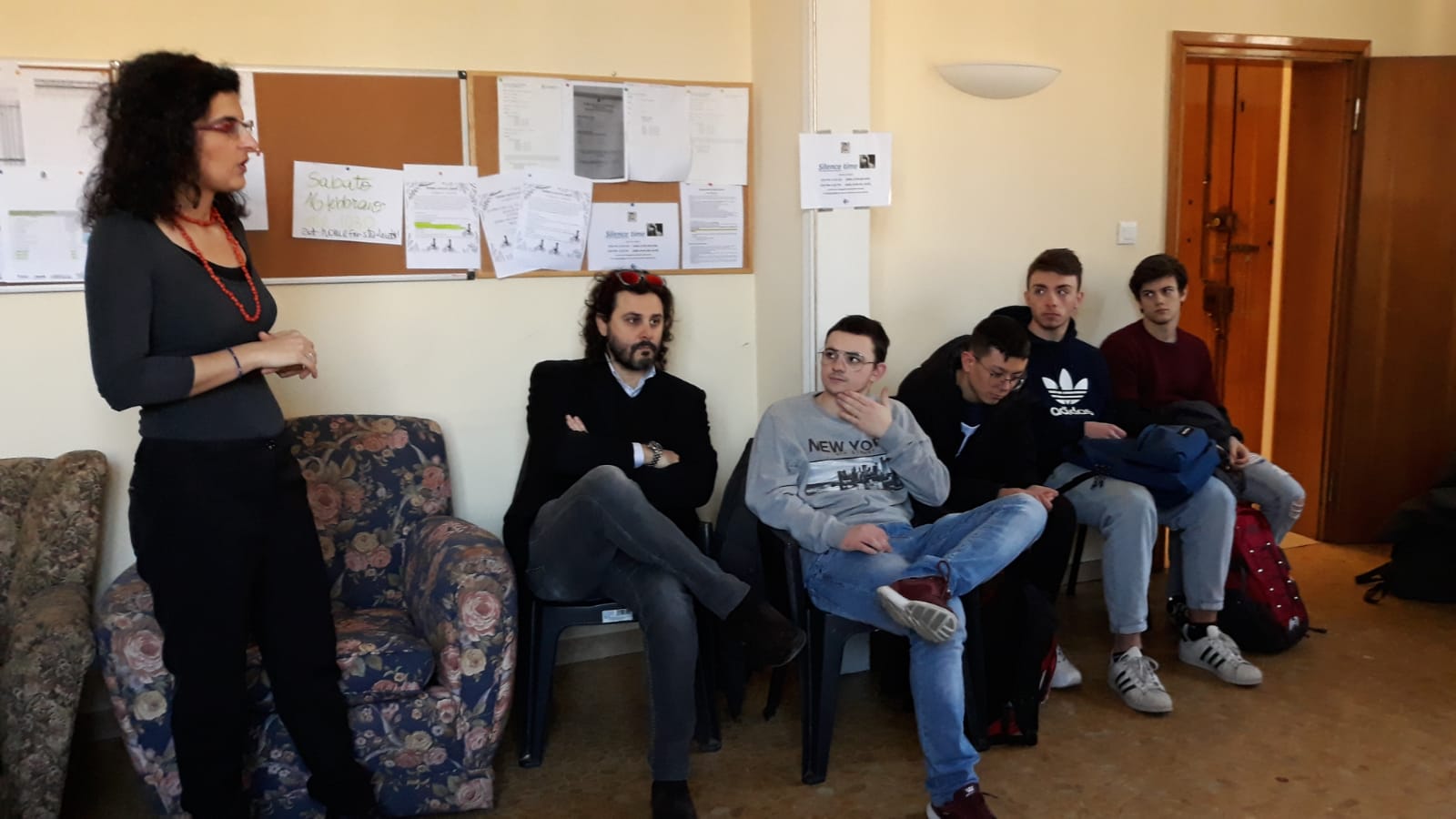 Un'immagine che ritrae capelli, viso, jeans, scarpa e braccio.
