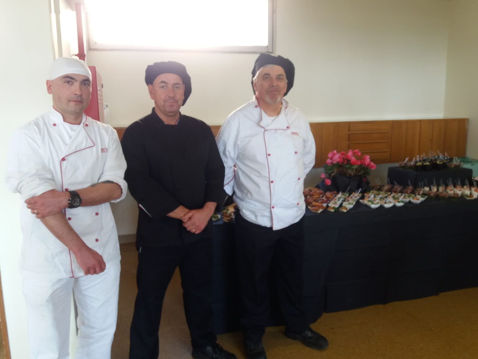 Un'immagine che ritrae sorriso, cappello, uniforme, cuoco e cucinare.
