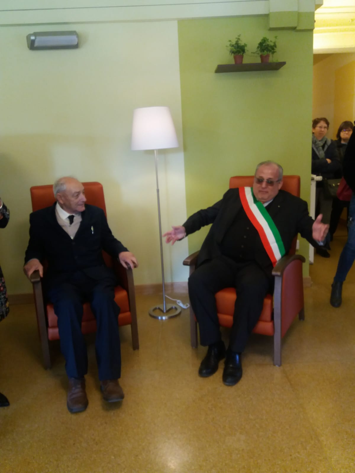 Un'immagine che ritrae mobilia, cappotto, sedia, pantaloni da abito e abito.