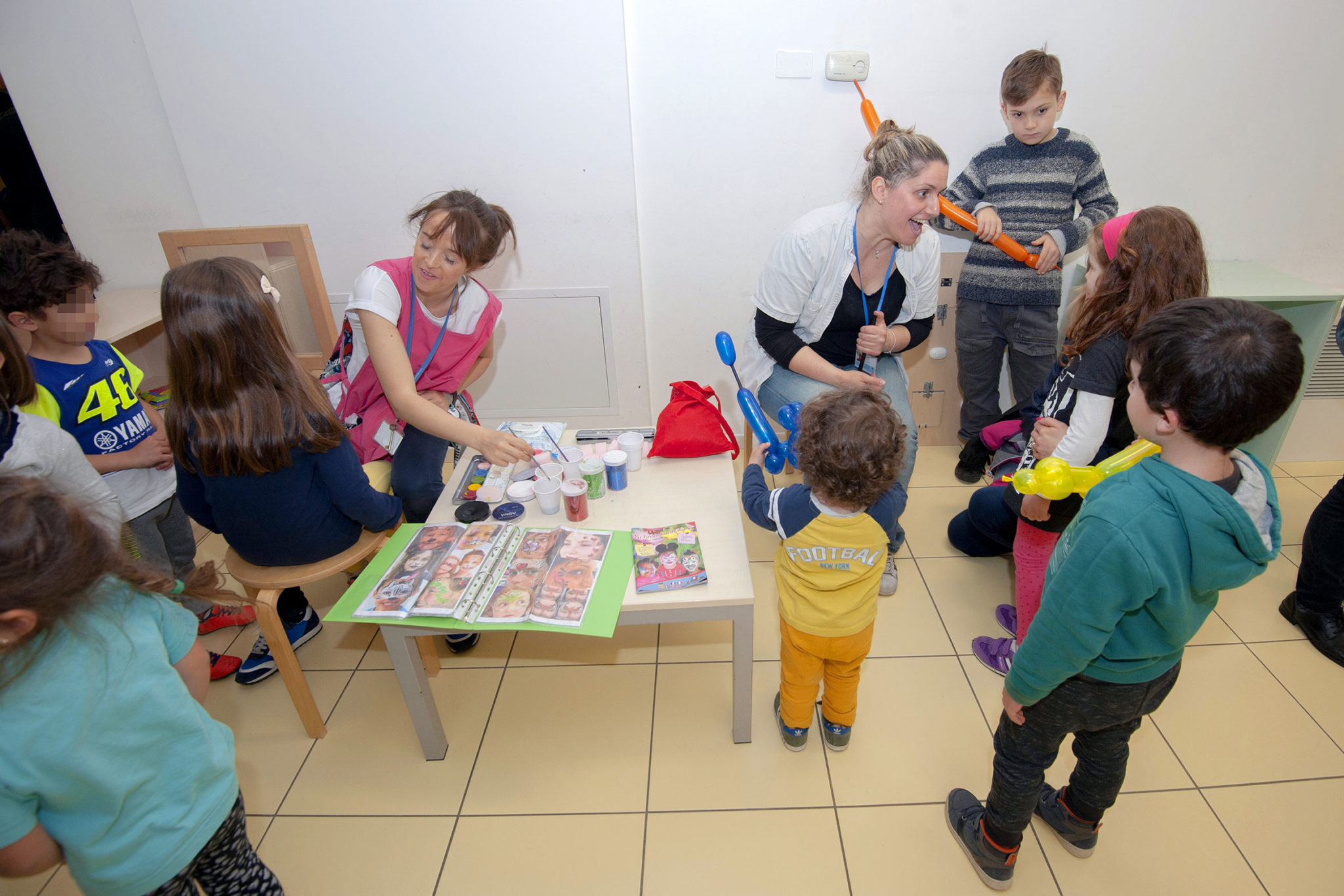 Un'immagine che ritrae braccio, maglietta, bambino, mobilia e camera.