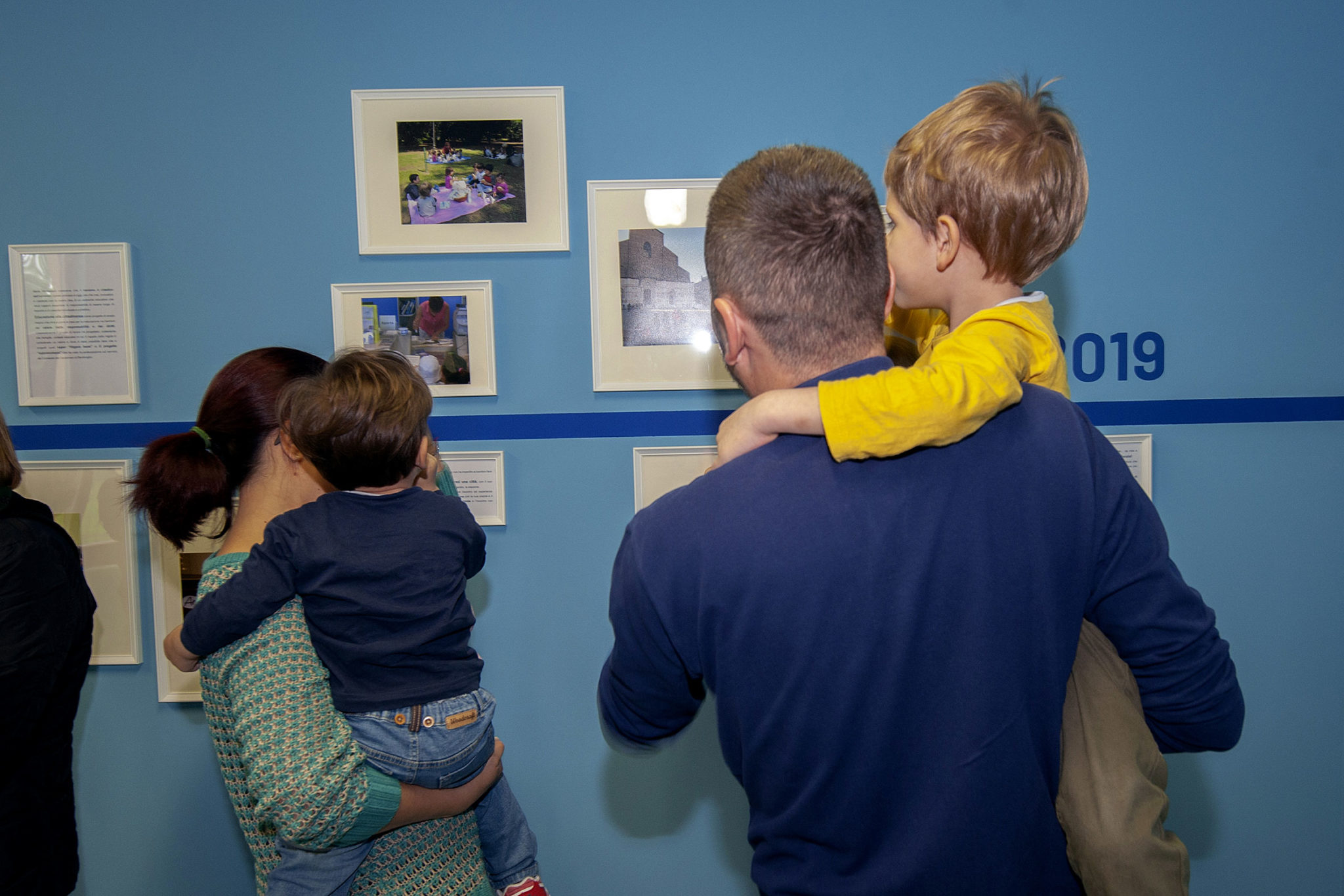 Un'immagine che ritrae persone, bambino, interazione, biondo e schiena umana.