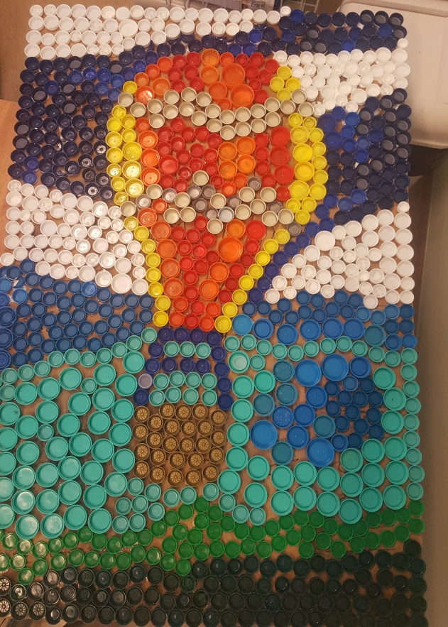 Un'immagine che ritrae arancia, mosaico, arti creative, tappo di bottiglia e arte moderna.