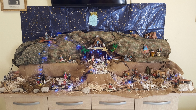 Un'immagine che ritrae decorazione natalizia, presepe, giocattolo, materiale naturale e tradizione.