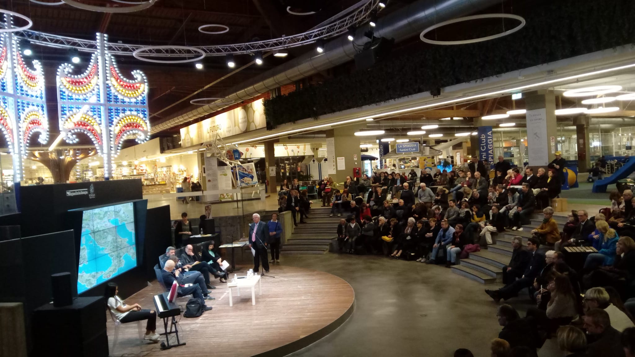 Un'immagine che ritrae evento, folla, soffitto, pubblico e sala.
