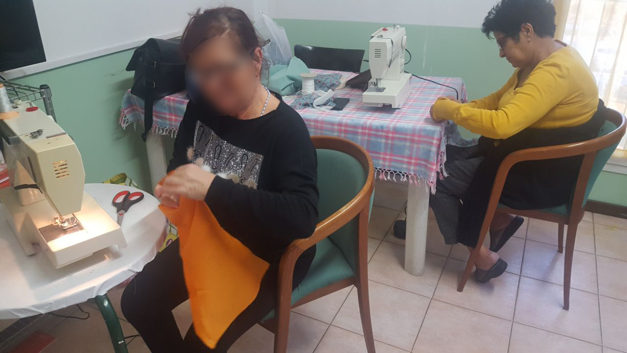 Un'immagine che ritrae mobilia, mano, tavolo, macchina da cucire e scrivania.