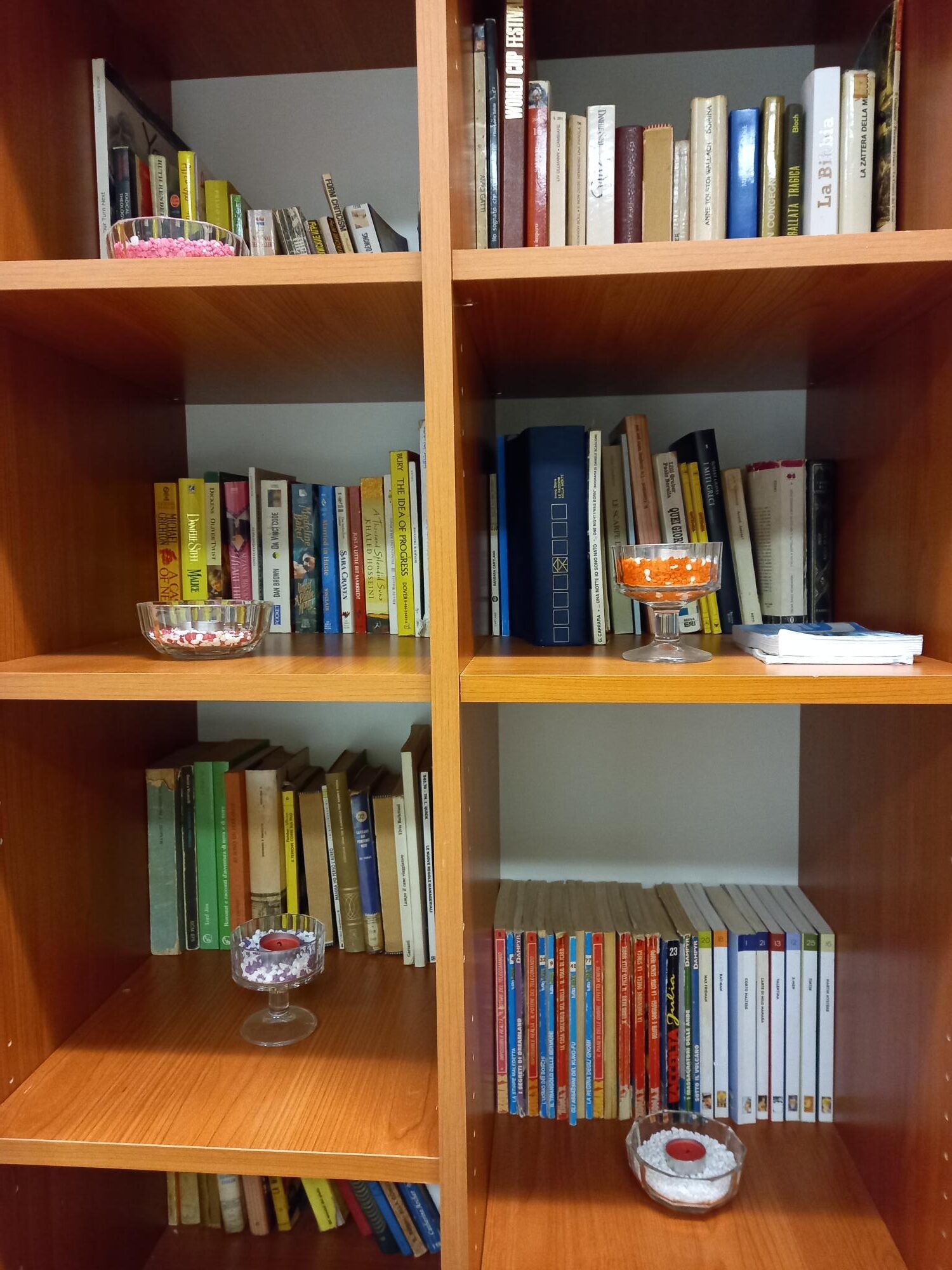 Un'immagine che ritrae mensola, libreria, scaffalature, mobilia e libro.