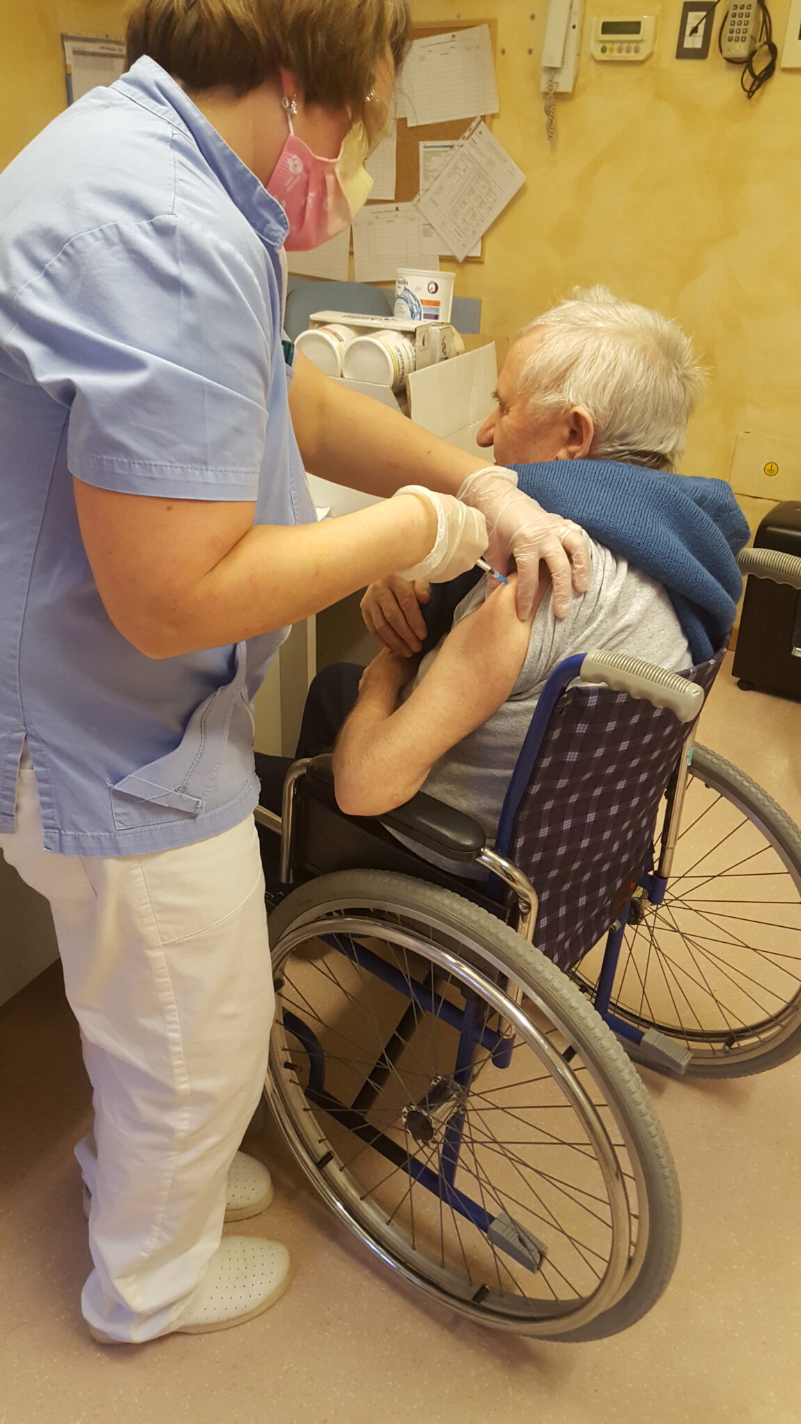 Un'immagine che ritrae sedia a rotelle, mobilia, paziente, attrezzature mediche e sedia.