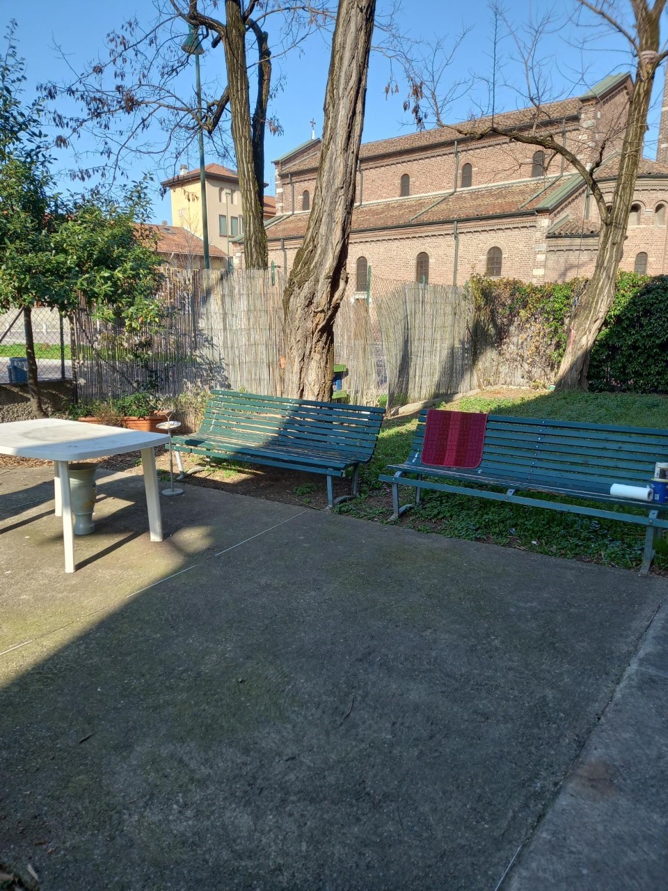 Un'immagine che ritrae spazio pubblico, panchina da esterno, ombra, mobili da esterno e cortile.