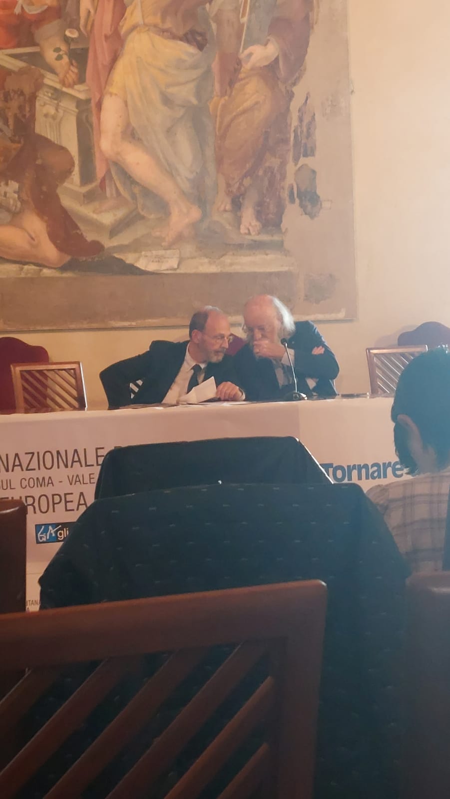 Un'immagine che ritrae abito, sedia, incontro, udito e collaborazione.