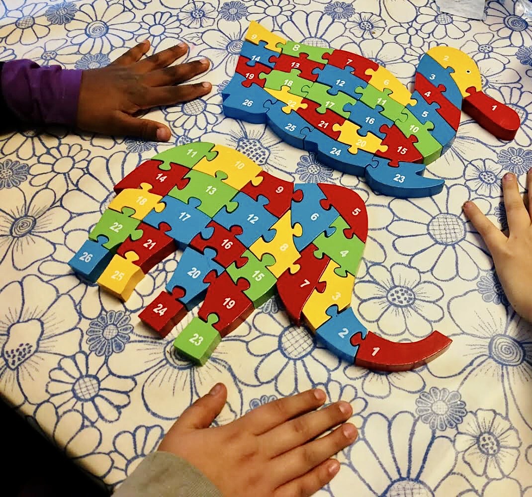 Un'immagine che ritrae puzzle, bambino, giocare, puzzle e giocattoli per bambini.