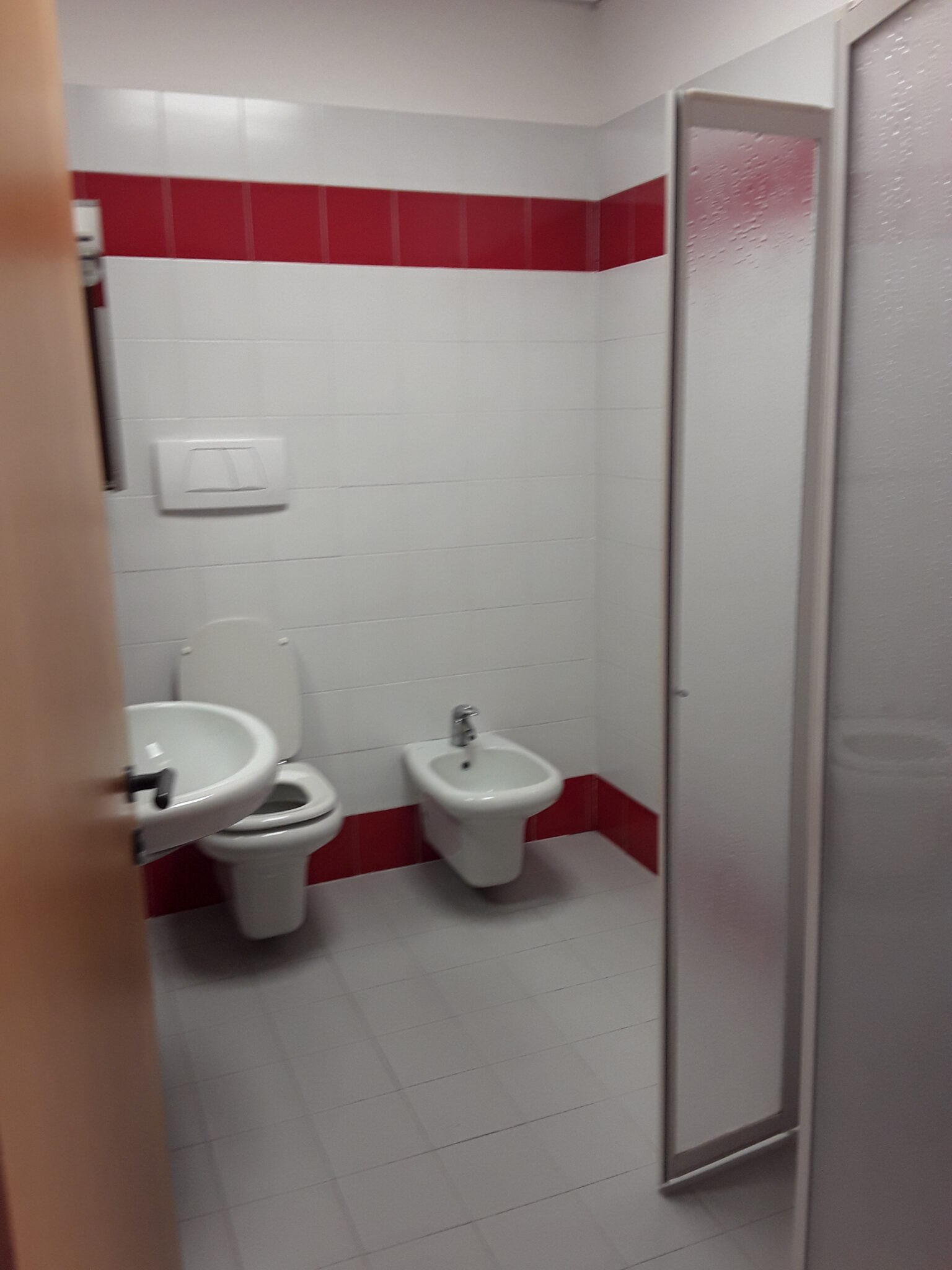 Un'immagine che ritrae rosso, apparecchio idraulico, pavimentazione, pavimento e bagno.
