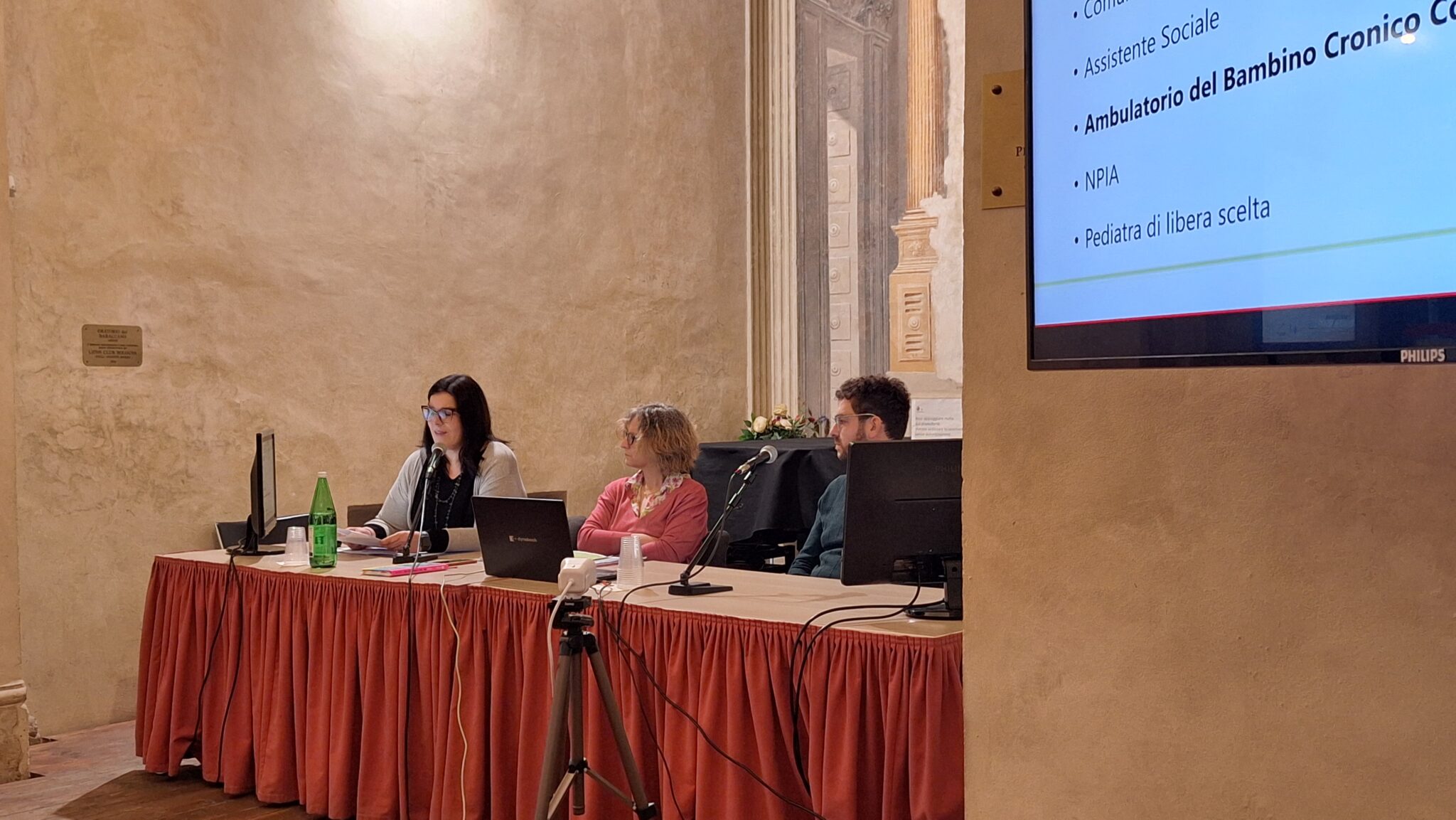 Un'immagine che ritrae mobilia, dispositivo elettronico, presentazione, schermo di proiezione e dispositivo di visualizzazione.