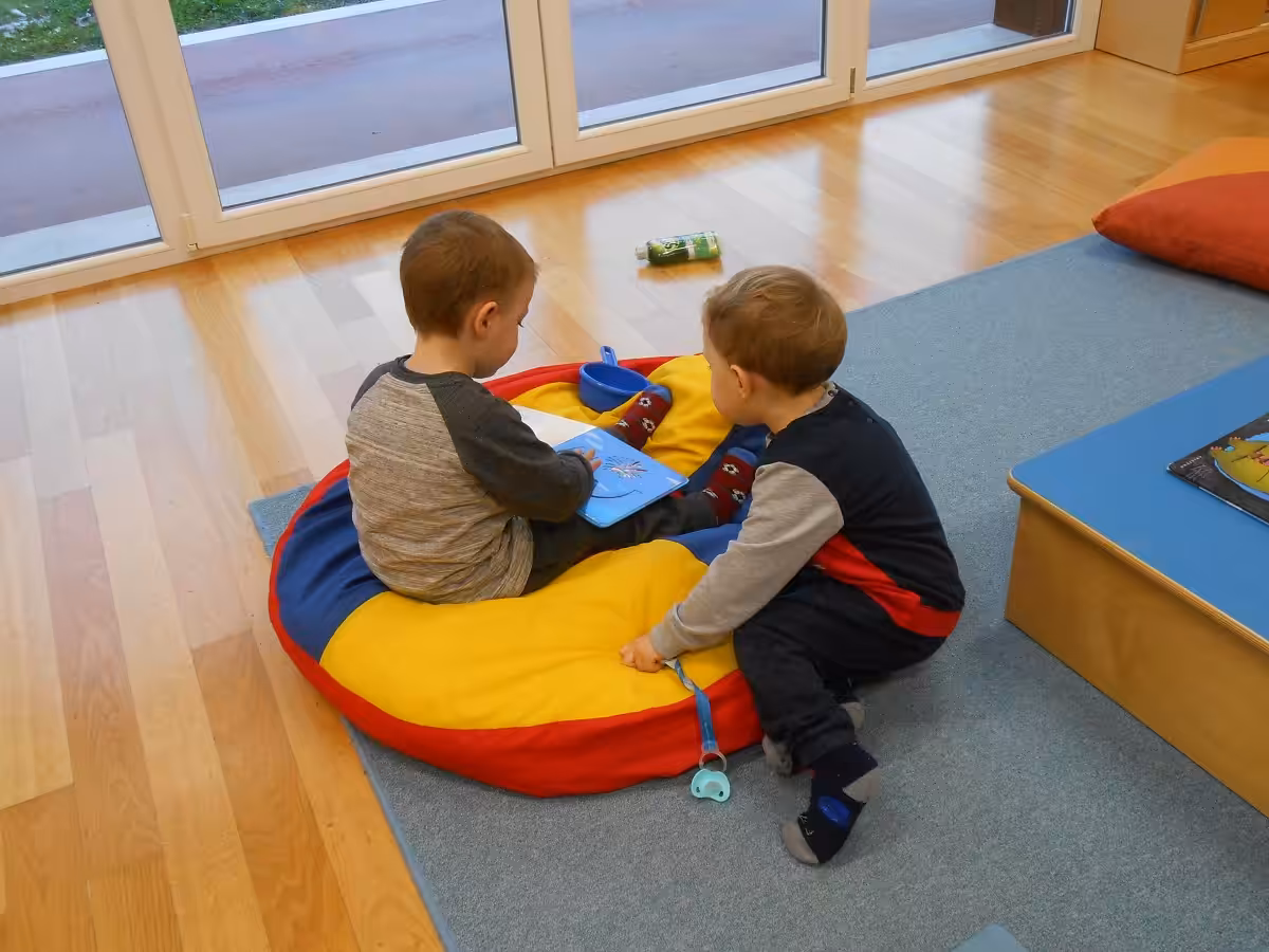 Un'immagine che ritrae bambino, pavimentazione, mobilia, seduta e pavimento.