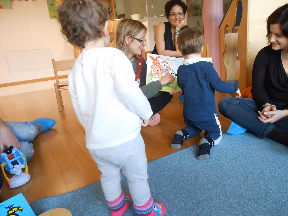 Un'immagine che ritrae capelli, braccio, pantaloni, scarpa e bambino.