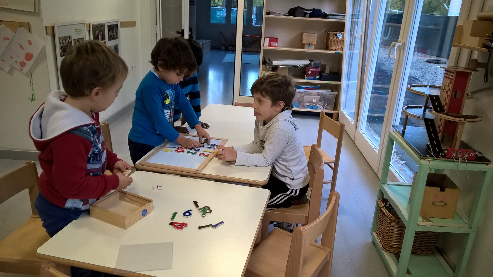 Un'immagine che ritrae mobilia, tavolo, bambino, scrivania e gioco.