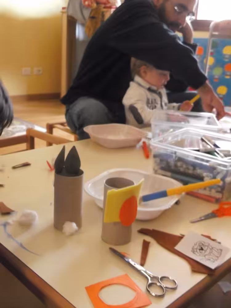 Un'immagine che ritrae mobilia, tavolo, carta, sedia e bambino.