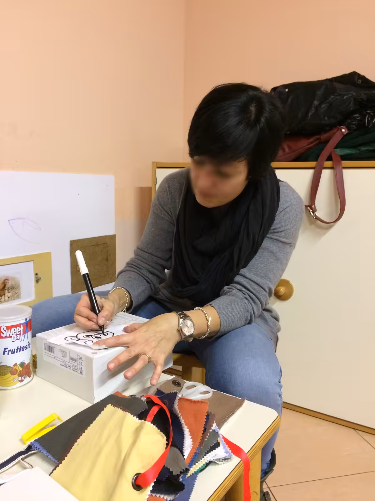 Un'immagine che ritrae mano, tavolo, mobilia, scrivania e carta.