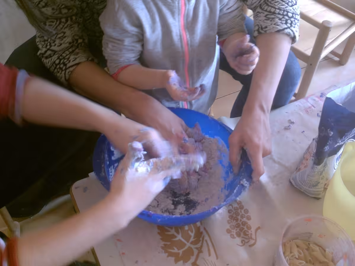 Un'immagine che ritrae mano, tavolo, stoviglie, bambino e polvere.