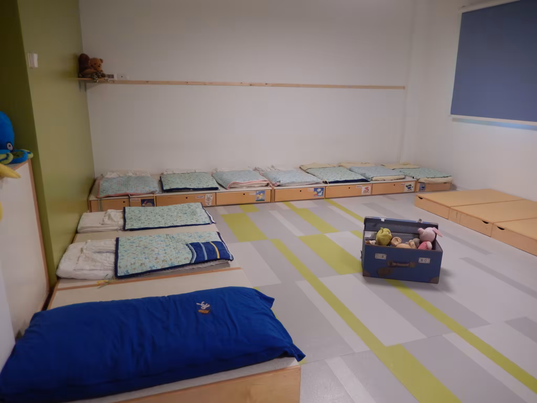 Un'immagine che ritrae pavimentazione, pavimento, camera, materassino e aula.