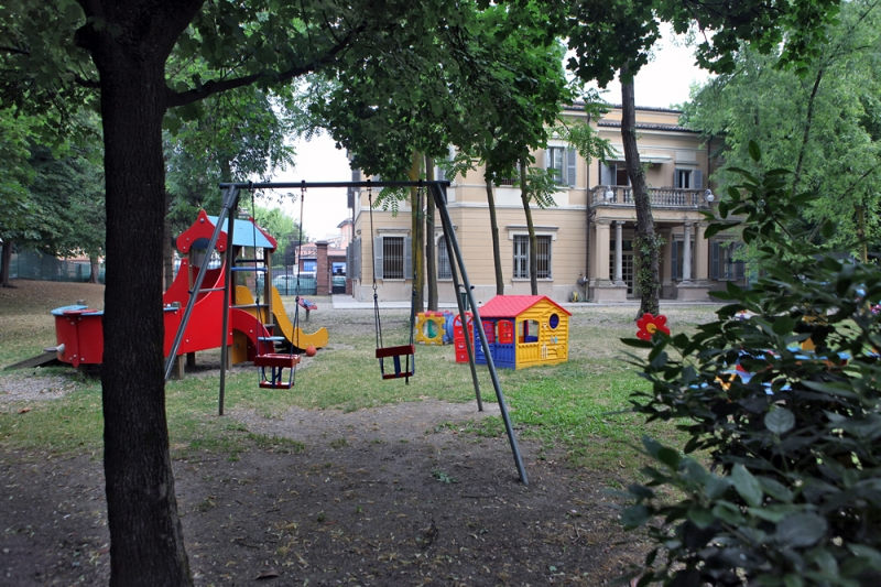Un'immagine che ritrae spazio pubblico, ombra, parco, cortile e attrezzature da gioco all'aperto.
