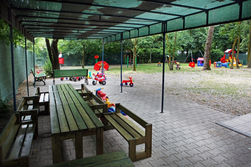 Un'immagine che ritrae spazio pubblico, ombra, panchina da esterno, panca e parco.