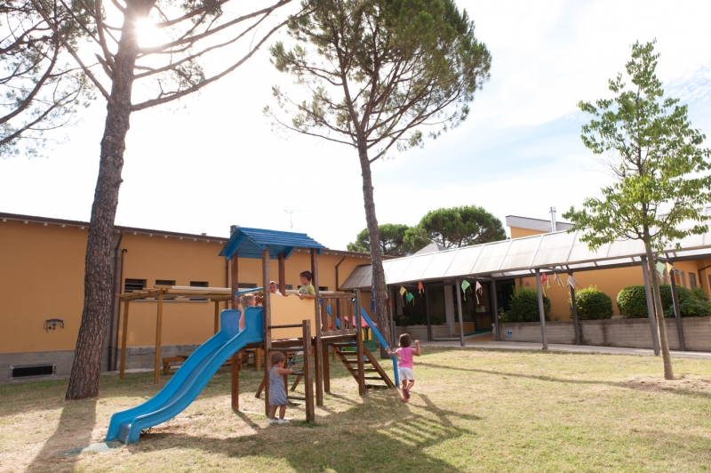 Un'immagine che ritrae spazio pubblico, insediamento umano, attrezzature da gioco all'aperto, ombra e scivolo da parco giochi.