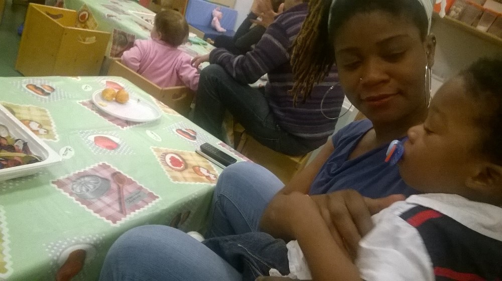 Un'immagine che ritrae camicia, mobilia, tavolo, bambino e sedia.