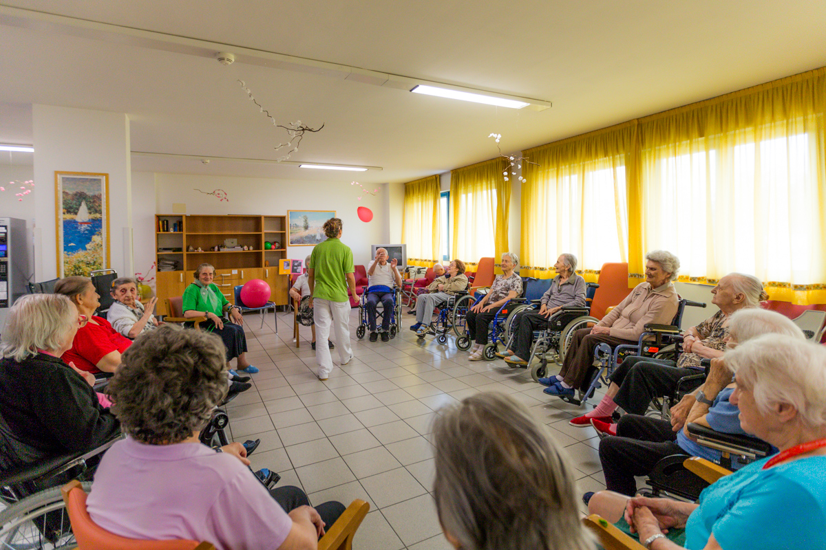 Un'immagine che ritrae comunità, sedia a rotelle, sedia, mobilia e seduta.