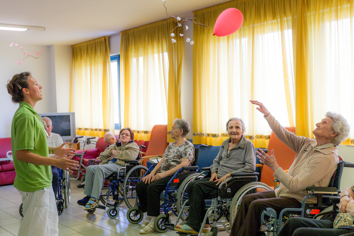 Un'immagine che ritrae sedia a rotelle, mobilia, sedia, seduta e casa di riposo.
