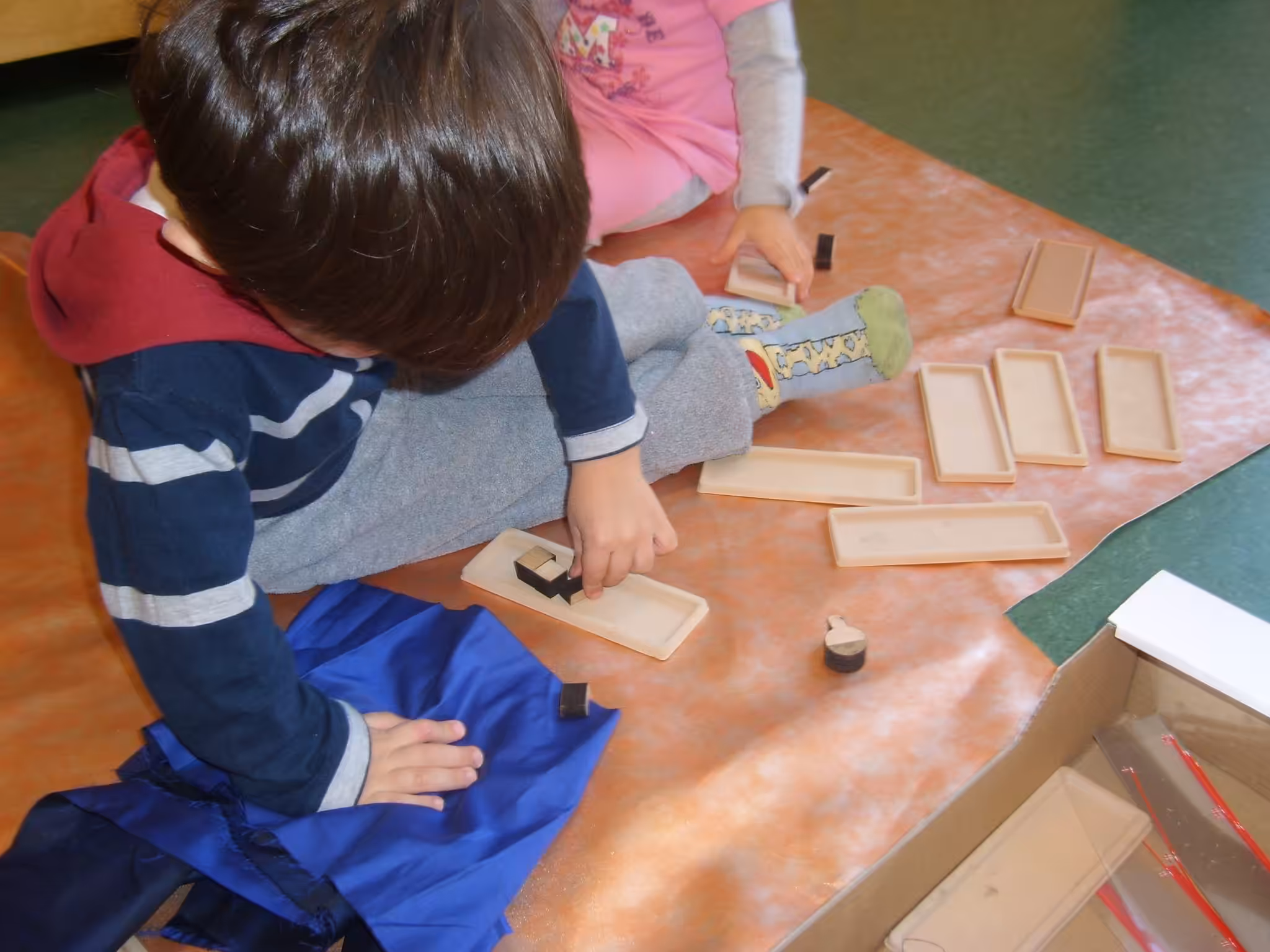 Un'immagine che ritrae dito, bambino, giocare, mordente per legno e prodotto di carta.