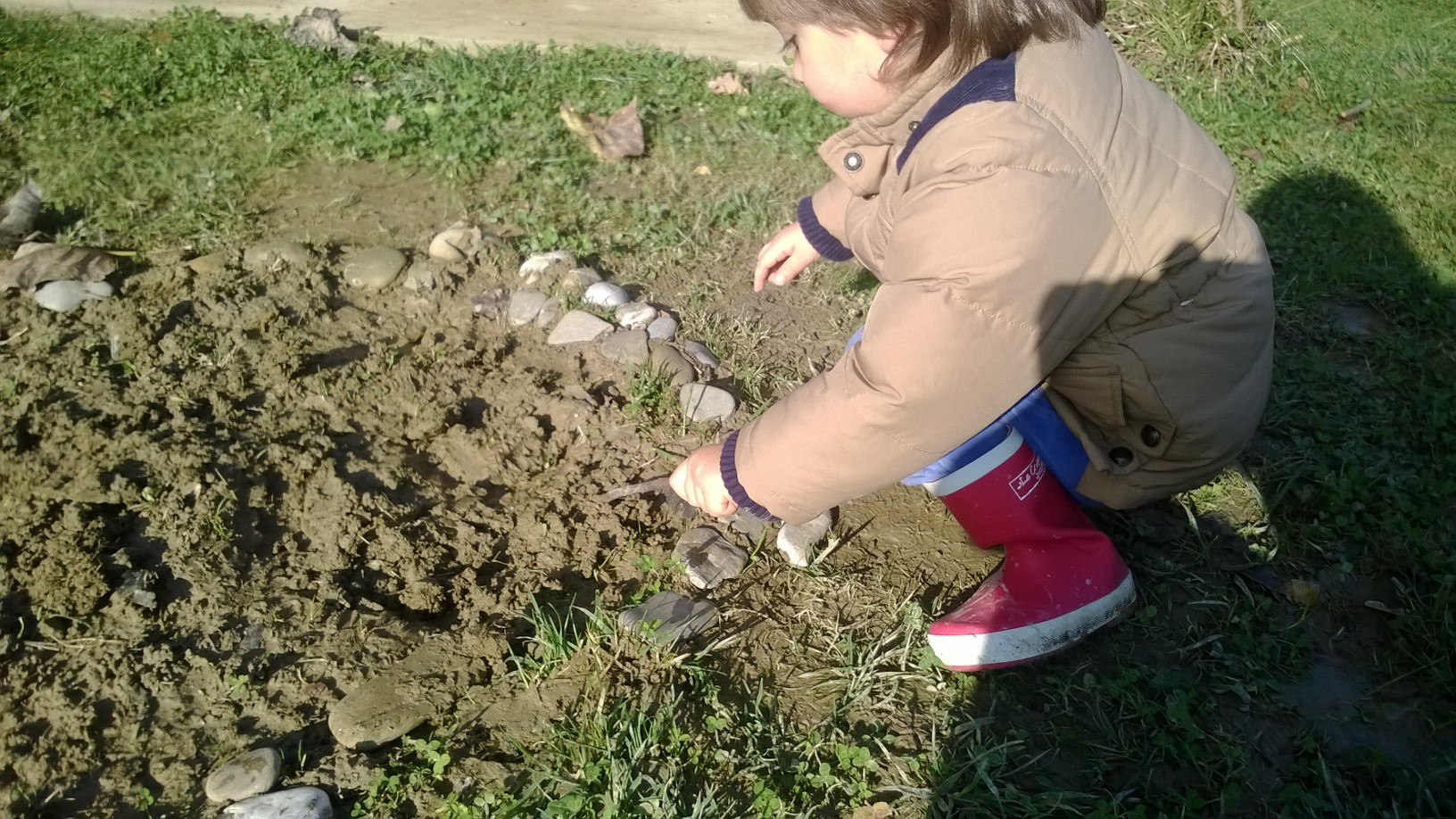 Un'immagine che ritrae suolo, bambino, giocare, bambino che fa i primi passi e scarpa da passeggio.